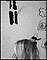 svartvitt foto: blont hår + hand syns av någon som står mot en vägg med teckningar på 