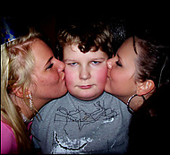 liten kille som får puss av två tjejer