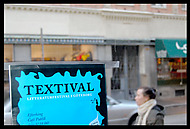 turkos Textival-skylt i fönster inifrån ut mot gatan