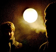 Två Ykkyredaktörer i mörker med lampa som ser ut som en måne och rök